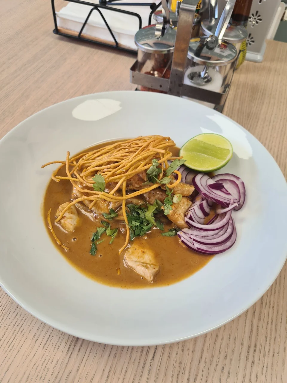 Khao Soi curry noodles with crispy noodles, lime and red onion at Charm Thai Cafe